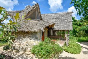 an old house with a straw roof at AFYA Village at the sea in Michamvi