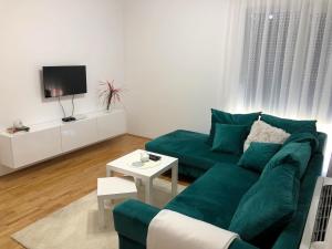 sala de estar con sofá verde y TV en B&S stan na dan, en Bijeljina