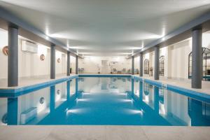 a swimming pool with blue water in a building at Comis Hotel & Golf Resort in Douglas