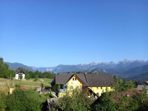 a house on a hill with mountains in the background at Tubej B&B family room with terrase in Bohinj