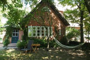 a red brick house with a hammock in front of it at Ferien in einem historischen Bauernhaus mit Garten in Möhnsen