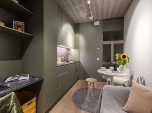 eine Küche und ein Wohnzimmer mit einem Sofa und einem Tisch in der Unterkunft Campus House by Larsen in Tallinn