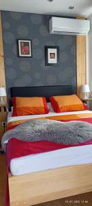 1 dormitorio con 2 camas con almohadas de color naranja y rojo en Apartment Travel hub ***, en Varaždin