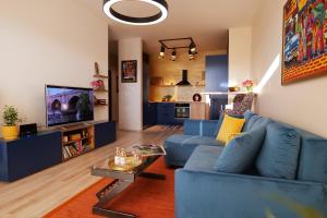 a living room with a blue couch and a tv at Apartmán - modern home in Bardejov