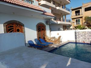 a house with a swimming pool next to a building at Villa Victoria Old Nile View in Luxor