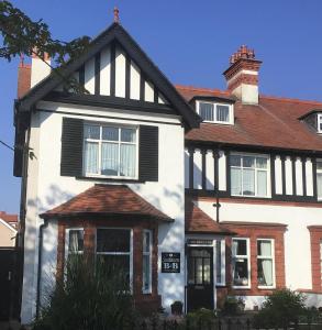 ein großes weißes Haus mit schwarzen Fensterläden in der Unterkunft Southbourne Guest House in Llandudno