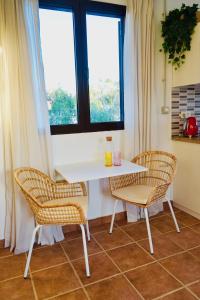 a white table and two chairs in a room with windows at Siempre Feliz La Casita Los Molinos in Villaverde