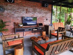 a living room with chairs and a television in a brick wall at TTS Lake Villa Broga Semenyih in Semenyih