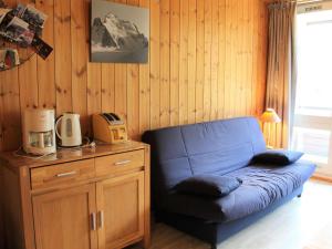 a blue couch in a room with a wooden wall at Appartement Vars, 1 pièce, 4 personnes - FR-1-330B-59 in Vars