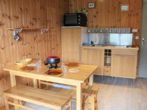 a kitchen with a wooden table with chairs and a counter at Appartement Vars, 1 pièce, 4 personnes - FR-1-330B-59 in Vars