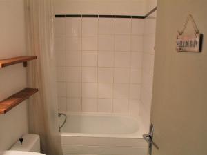 a bathroom with a bath tub and a toilet at Appartement Vars, 1 pièce, 4 personnes - FR-1-330B-59 in Vars