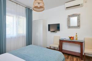 Dormitorio con cama, escritorio y TV en Studio apartment Tramonto, en Cavtat