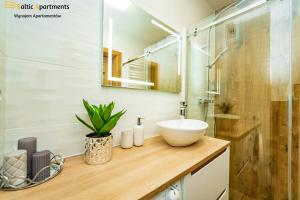 łazienka z umywalką i przeszkloną kabiną prysznicową w obiekcie Baltic Apartments - Sun Towers w Świnoujściu