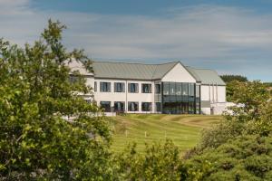 ダグラスにあるComis Hotel & Golf Resortの木立の丘の上の大白い家