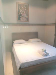 1 dormitorio con 1 cama con 2 toallas en Dewi Antara Homestay, en Ubud