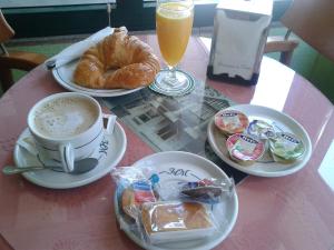 a table topped with plates of food and cups of coffee at Hotel Madrid in Pontevedra