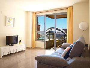 a living room with a couch and a television at ApartUP Yellow Opera View in Valencia