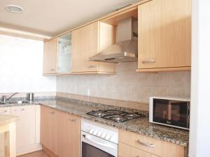a kitchen with wooden cabinets and a stove top oven at ApartUP Yellow Opera View in Valencia