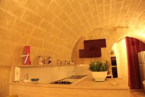 cocina con fregadero y pared con arco en La Conchiglia Nei Sassi, en Matera