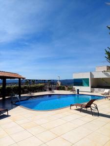 a swimming pool with chairs and a view of the ocean at Casa no Mirante de Escarpas in Capitólio