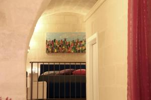 Un dormitorio con una pintura en la pared y una cama en La Conchiglia Nei Sassi, en Matera