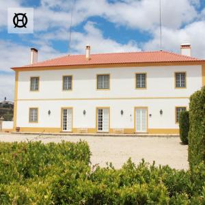 un gran edificio blanco con techo rojo en Herdade da Ordem, en Cabeço de Vide