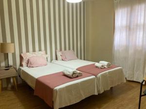 twee bedden naast elkaar in een kamer bij La casita de luis in Granada
