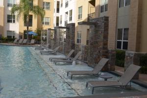 - une rangée de chaises longues à côté de la piscine dans l'établissement Domain at CityCentre, à Houston