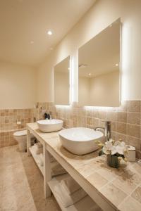 a bathroom with two sinks and a large mirror at Comis Hotel & Golf Resort in Douglas
