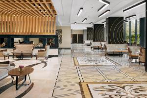 a lobby with chairs and a fireplace at Mövenpick Hotel Karachi in Karachi