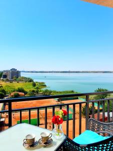 a table and chairs on a balcony with a view of the water at Coral Residence -Mamaia Nord in Mamaia