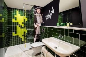 a bathroom with a toilet and a sink and green tiles at nhow London in London