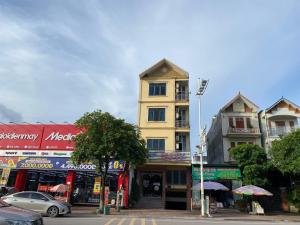 un edificio alto amarillo al lado de una calle en Nhà nghỉ FAMY, en Móng Cái