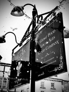 ein Straßenschild an einem Straßenlicht mit Schildern darauf in der Unterkunft Cain Valley Hotel in Llanfyllin