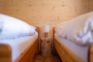 a bedroom with two beds and a table with a lamp at Hüttenresort Mare in Fichtelberg