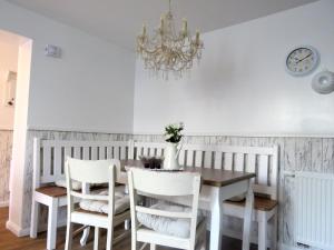 a dining room table with white chairs and a chandelier at Gut Brüggen in Kerpen
