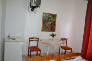 a room with a table and chairs and a painting at Studio Lantzos in Oreoi