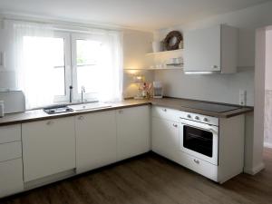 a kitchen with white cabinets and a sink and a window at Gut Brüggen in Kerpen