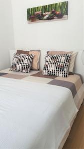 Una cama blanca con dos almohadas encima. en Chez Esmara et Philippe Grand-Place, en Bruselas