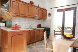 a kitchen with wooden cabinets and a table with a bowl of fruit at Lemon tree house in Kalloni