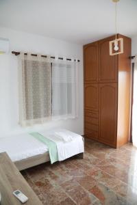 1 dormitorio con 1 cama y armario de madera en Lemon tree house en Kalloni