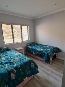 a bedroom with two beds and two windows at Lifestyle Golf Estate in Pietermaritzburg