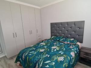 a bedroom with a bed with a blue comforter at Lifestyle Golf Estate in Pietermaritzburg