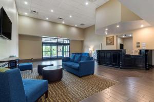 a waiting room with blue chairs and a flat screen tv at Comfort Suites in Kingsport