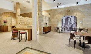 a restaurant with tables and chairs and a stone wall at Sercotel Calle Mayor in Logroño