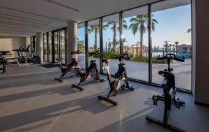 a gym with cardio equipment in a building with palm trees at Hyatt Regency Taghazout in Taghazout
