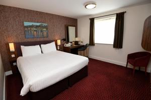 a hotel room with a large bed and a window at Penny Hedge, Whitby by Marston's Inns in Whitby