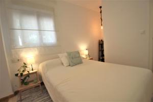 洪達海灘的住宿－Adosado La Salada by Rental Olé，卧室配有白色的床和窗户。