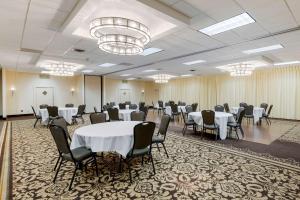 a conference room with tables and chairs and a chandelier at Clarion Inn Elmira-Horseheads in Elmira
