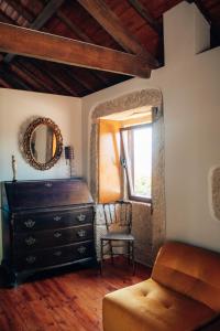 a room with a dresser and a chair and a mirror at Just Like Home - Holly House em Cerveira in Reboreda